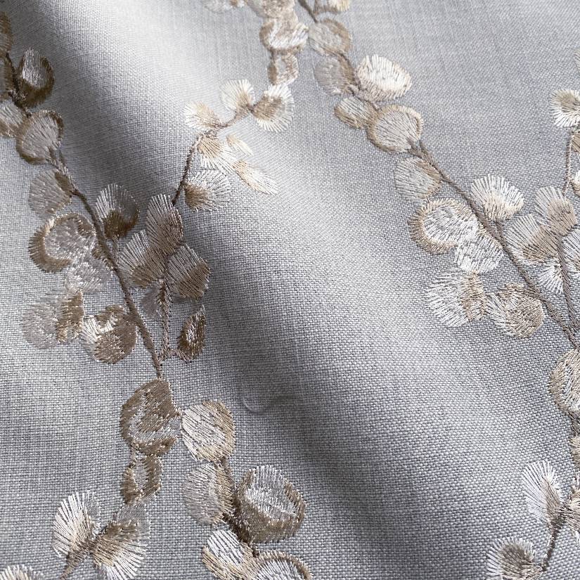 Embroidered floral blue pillow with linen fabric background