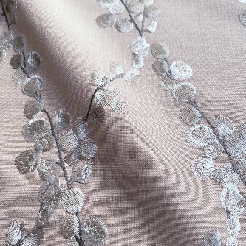 Embroidered floral pink pillow with linen fabric background